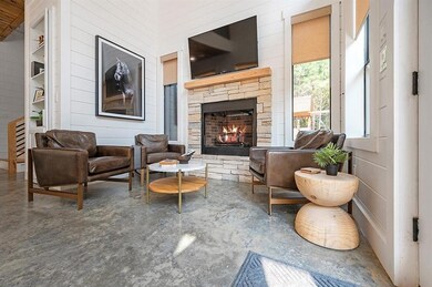 Living room featuring built in shelves, a stone fi