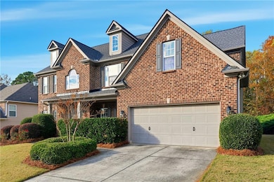 Traditional-style home with brick siding, driveway, an attached garage, and roof with shingles