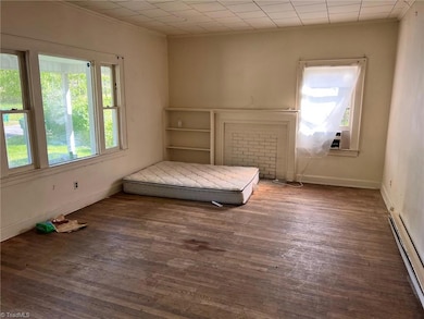 Large living area features wood flooring and large windows.