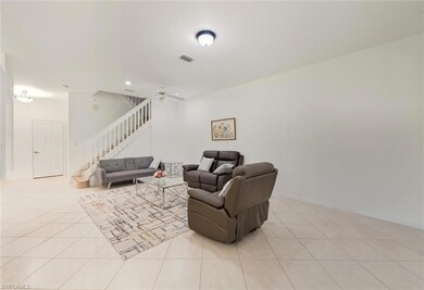 Living room featuring light tile patterned floors, stairs, a ceiling fan, and recessed lighting