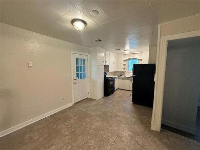 Kitchen featuring black appliances, white cabinetry, open shelves, baseboards, and light countertops