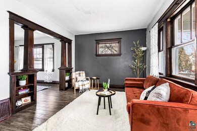 Living room featuring ornate columns, dark wood-ty
