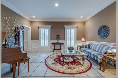 To the left of the foyer is an impressive parlor with high-quality molding and wainscoting. The home was designed with entertaining top of mind—every room flows gracefully into the next, anchored by a duo of cozy fireplaces.