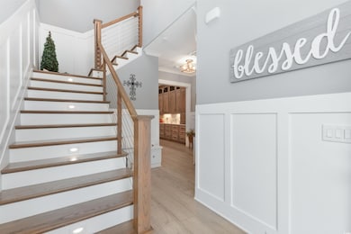 Stairway with wood finished floors and ornamental molding