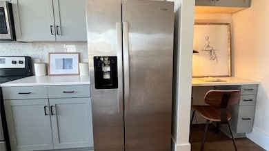 Modern kitchen with stainless steel appliances, including a large fridge. Sleek cabinetry offers ample storage.