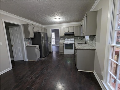 Kitchen with sink, dark hardwood / wood-style floors, white range with electric stovetop, gray cabinets, and backsplash
