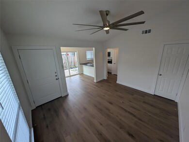 Entryway with lofted ceiling, a ceiling fan, dark
