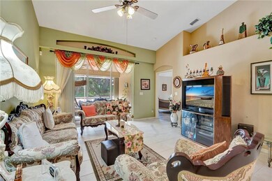Living room featuring a ceiling fan, light tile pa