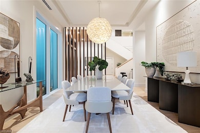 Dining area with wood finished floors, a chandelier, and a raised ceiling