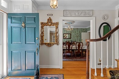 Foyer entrance featuring wood finished floors, orn
