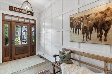Entryway featuring a notable chandelier, wood-type flooring, and crown molding