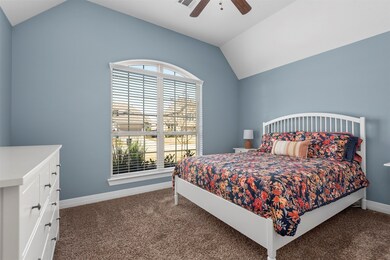 Spacious secondary bedroom with high ceilings, ceiling fan, two inch blinds and a large closet.