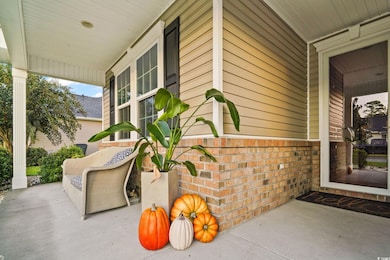View of exterior entry with covered porch and brick siding