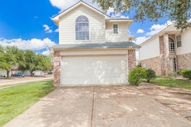 Front view of the two-story brick and siding exterior with attached two-car garage.