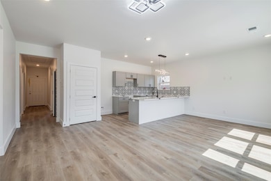 Kitchen featuring a peninsula, visible vents, ligh