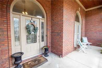Property entrance with brick siding and a porch
