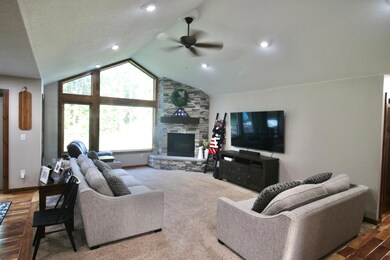 Spacious living room with vaulted ceilings, a gas fireplace, and floor to ceiling windows offering tons of natural light..jpg