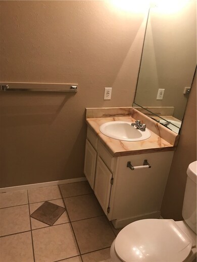 Bathroom with toilet, vanity, and tile patterned floors