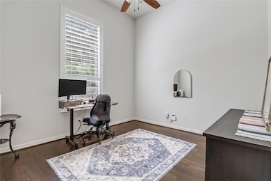Office area featuring a ceiling fan and dark wood