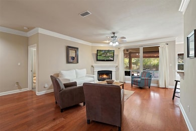 Living area featuring a warm lit fireplace, hardw