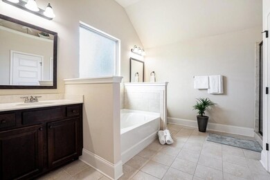 The Spa-Like Bathroom includes a Double Vanity with Stone Countertops, a Soaking Tub, Separate Glass Shower, and a Large Walk-In Closet.