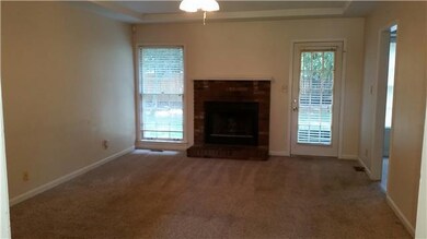Living room with wood burning fireplace.  Carpet r