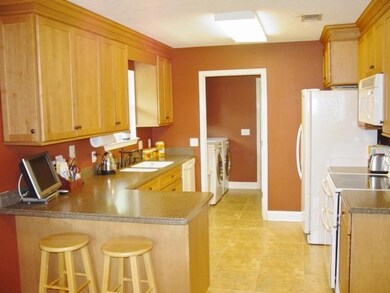 Kitchen has been upgraded with custom cabinets, solid surface counters, under mount sink, and ceramic tile floor.