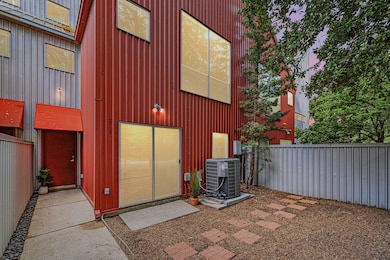 Modern townhouse with a striking red exterior, lar