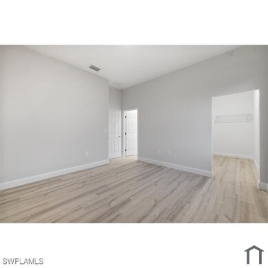 Unfurnished room featuring visible vents, light wo
