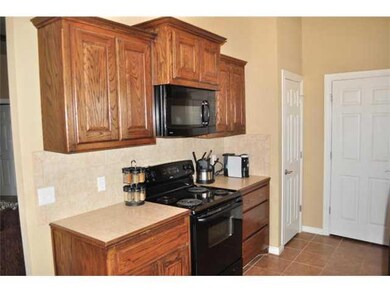 Kitchen. The kitchen features tile counters, rich 