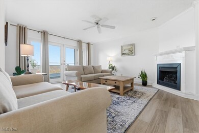 Living area with light wood-style floors, a fireplace, a ceiling fan, crown molding, and french doors