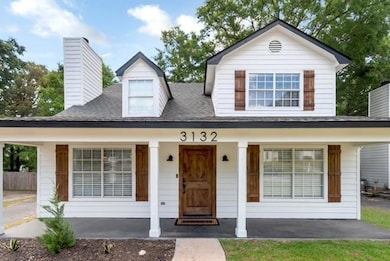 View of front of house with a porch, a chimney, and a shingled roof