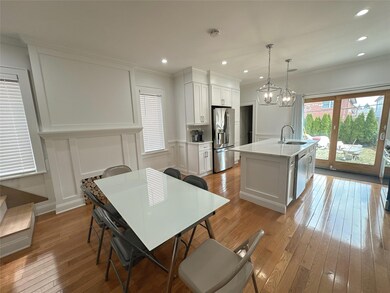Kitchen featuring a decorative wall, a sink, stainless steel appliances, and ornamental molding