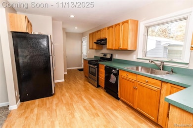 Kitchen with appliances with stainless steel finishes, light wood-style floors, under cabinet range hood, and recessed lighting