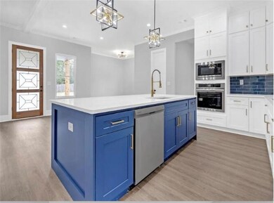 Kitchen featuring blue cabinetry, appliances with 