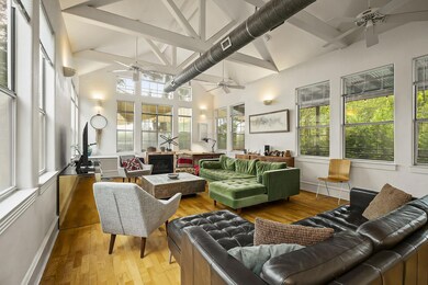 Sunroom / solarium featuring wood-type flooring, high vaulted ceiling, beam ceiling, and healthy amount of natural light