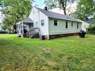 Rear view of property featuring a yard, a sunroom,