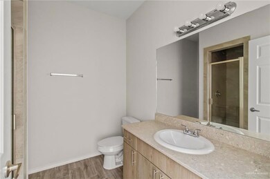 Bathroom featuring hardwood / wood-style flooring, vanity, toilet, and a shower with shower door