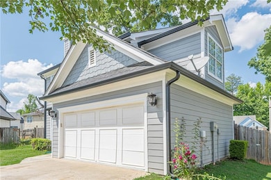 View of side of property featuring a garage, fence