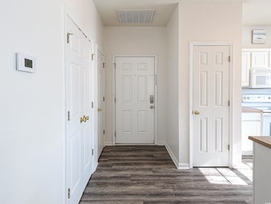 Corridor with dark hardwood / wood-style flooring