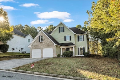 Traditional home featuring driveway, a garage, a front yard, and brick siding