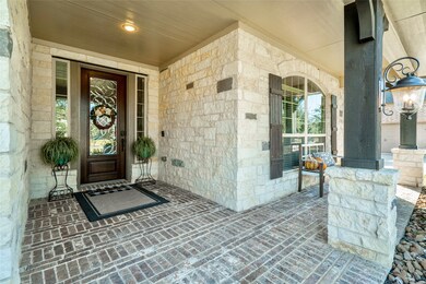This charming covered front porch draws the eye to the beautiful stonework that compliments the brick work and columns.