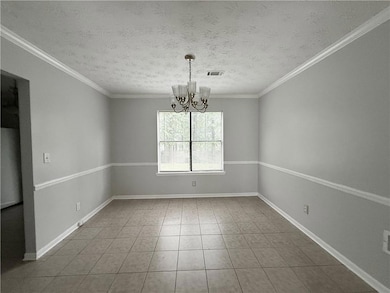 Spare room with a chandelier, a textured ceiling, tile patterned flooring, and crown molding