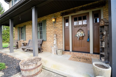 View of exterior entry with a porch and brick siding