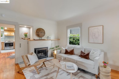 Living area with light wood-type flooring and a glass covered fireplace