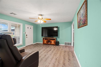 Living room with ceiling fan and light wood finished floors