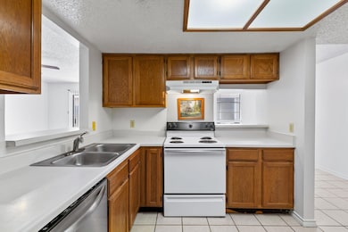 Kitchen with white electric stove, under cabinet 