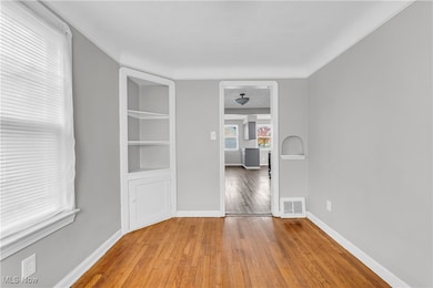 Spare room with hardwood / wood-style floors and built in shelves