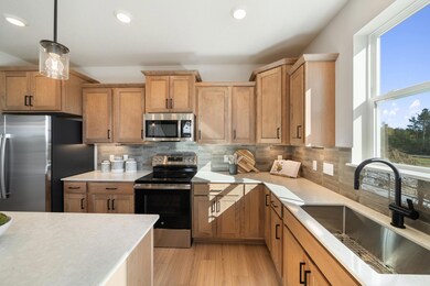 The kitchen features stained cabinets with stainless steel appliances.