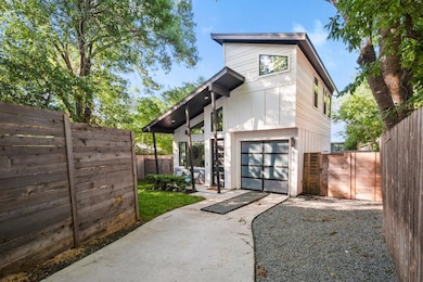 Modern home with driveway, a gate, and an attache